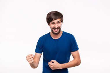 Mavi gömlek bıyıklı genç brunet sakallı adam kollarını beyaz arka plan üzerinde izole duran zafer jest ifade poz.