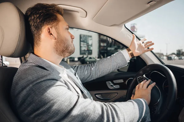 Angry driver in a traffic jam loosing his tamper and gesturing to let his car go. Being late