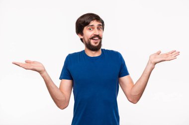 Sakallı mavi gömlekli iyi görünümlü brunet adam ve çoğu beyaz arka plan üzerinde izole duran habersiz ayakta omuzlarını silkme.