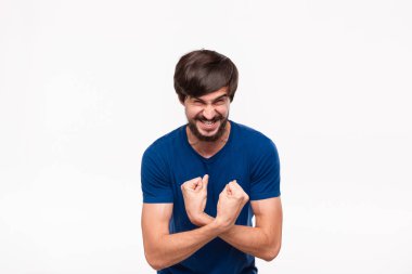 Komik iyi görünümlü brunet sakallı adam beyaz arka plan üzerinde izole ayakta pazı gösteren mavi gömlek bıyıklı.