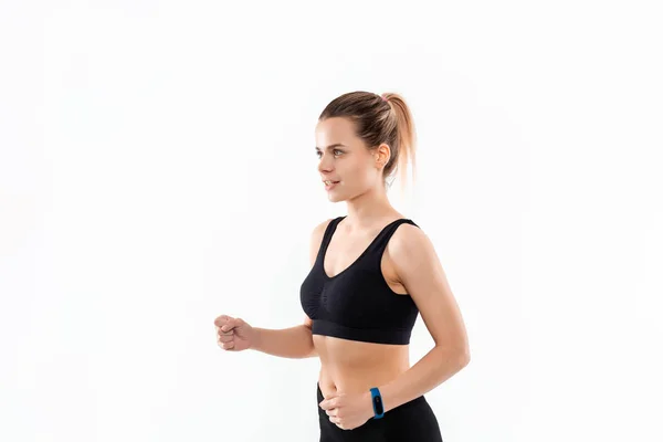 Jovem mulher loira desportiva em um sportswear preto correndo isolado sobre fundo branco . — Fotografia de Stock