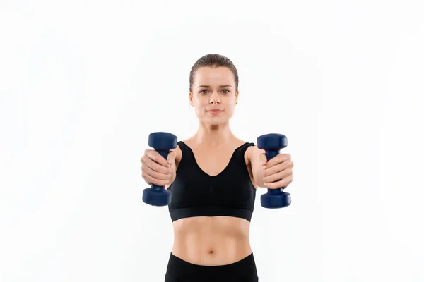 Jovem mulher loira desportiva em um sportswear preto exercitando com pesos de mão isolados sobre fundo branco . — Fotografia de Stock