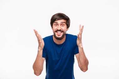 Sakallı mavi gömlekli yakışıklı brunet adam ve çoğu ağrılı bağırarak omuzlarını silkerek beyaz arka plan üzerinde izole ayakta şaşırıyor.