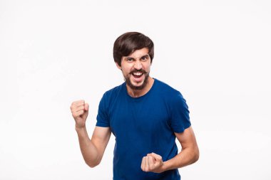 Mavi gömlek bıyıklı genç brunet sakallı adam kollarını beyaz arka plan üzerinde izole duran zafer jest ifade poz.
