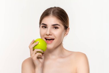 Beyaz arka plan üzerinde izole yeşil elma ısırma mutlu bir güzel genç kız yakın çekim portre. Güzellik ve sağlık kavramı.