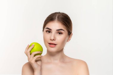 Beyaz arka plan üzerinde izole yeşil elma tutan mutlu bir güzel genç kız yakın çekim portre. Güzellik ve sağlık kavramı.