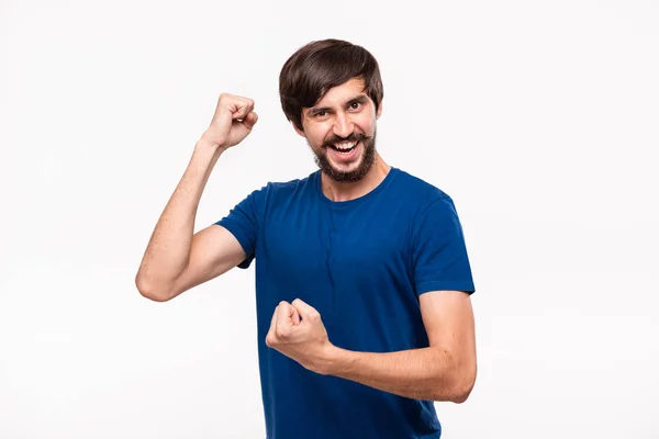 青いシャツに口ひげを生やした若いあごひげの男は、白い背景の上に立って腕を組んで幸運のジェスチャーを表現している。成功の概念. — ストック写真