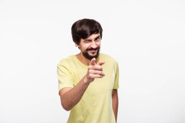 Mutlu brunet sakallı adam sarı bir t-shirt ile bıyıkları izleyiciye parmakları ile işaret. Olumlu duygu düşünme kavramı. Şimdi sen!