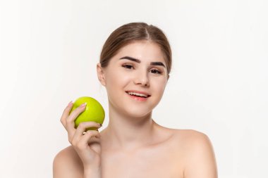 Beyaz arka plan üzerinde izole yeşil elma tutan mutlu bir güzel genç kız yakın çekim portre. Güzellik ve sağlık kavramı.