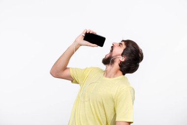 Sarı bir t-shirt şarkı ve dans spartphone ve kablolu kulaklık ile müzik zevk bıyıklı Yakışıklı brunet sakallı adam.