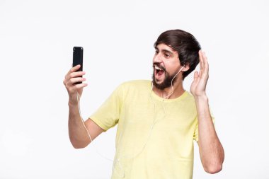 Bıyıklı yakışıklı brunet sakallı adam beyaz arka plan üzerinde izole bir akıllı telefon ile görüntülü sohbet yoluyla arkadaşlarınızla konuşurken.