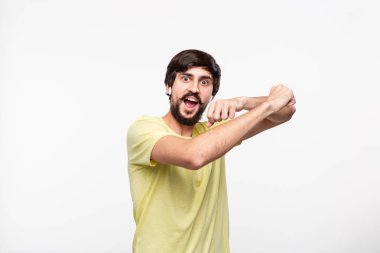 Heyecanlı brunet sakallı adam bıyıklı sarı bir t-shirt kablosuz kulaklık ve beyaz arka plan üzerinde izole dans şarkıları müzik zevk.