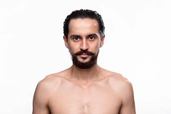 Hombre barbudo seguro con bigote parado desnudo sobre fondo blanco. Concepto de tratamiento matutino, afeitarse y prepararse para un nuevo día . —  Fotos de Stock