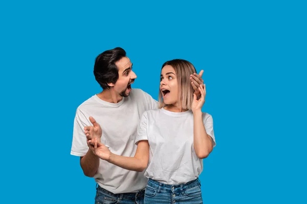 Beyaz t-shirt ve mavi kot mavi arka plan üzerinde izole poz bıyıklı genç sarışın kadın ve brunet sakallı adam Mutlu bir çift. İdeal çift.