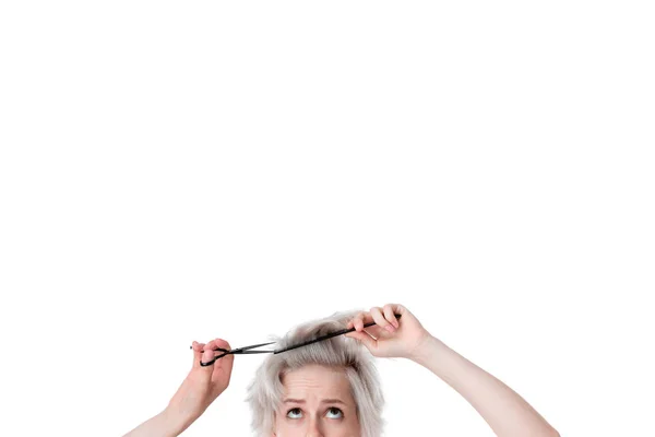 Close-up photo of a pretty young blond hairdresser cutting hair herself expressing emotion of  doubt. Beauty industry and professional career. — Stock Photo, Image