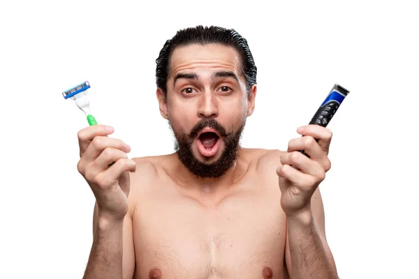 Bıyıklı sakallı adam elektrikli jilet ve eski tıraş çubuğu standning çıplak beyaz arka plan üzerinde izole arasında seçim yapıyor. Sabah tedavisi ve tıraş. Sakalını kesme zamanı.