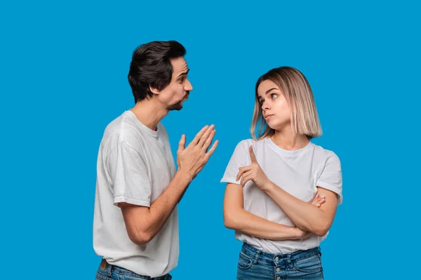 Hombre barbudo Brunet con bigotes en camiseta blanca y vaqueros azules pidiendo perdón a su novia aislado sobre fondo azul. Concepto de culpa . — Foto de Stock