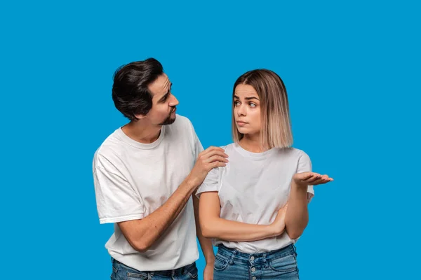 Bruno uomo barbuto con i baffi in t-shirt bianca e jeans blu chiedendo alla sua ragazza il perdono isolato su sfondo blu. Concetto di colpa . — Foto Stock