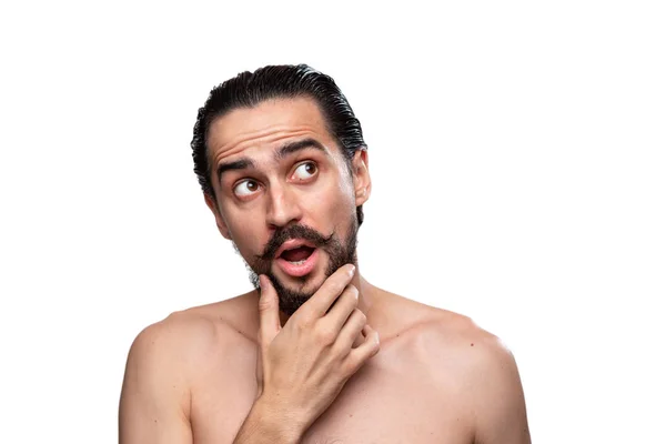 Pensativo hombre barbudo guapo con bigotes de pie desnudo aislado sobre fondo blanco y mirando a la cámara. Concepto de tratamiento matutino. Rutina matinal — Foto de Stock