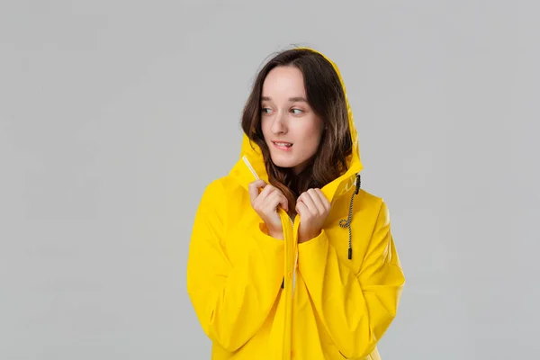 Lachend brunette meisje in een gele regenjas. Bereid je voor op slecht weer. — Stockfoto