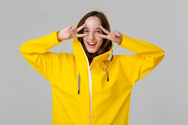 Chica morena sonriente con un impermeable amarillo. Prepárate para el mal tiempo . —  Fotos de Stock