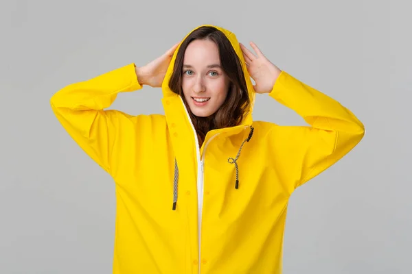 Chica morena sonriente con un impermeable amarillo. Prepárate para el mal tiempo . —  Fotos de Stock