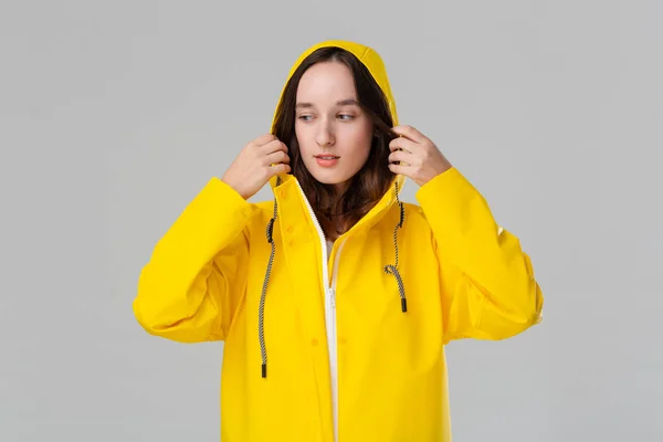 Chica morena sonriente con un impermeable amarillo. Prepárate para el mal tiempo . — Foto de Stock