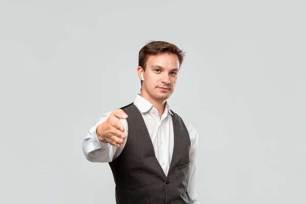 Joven hombre de negocios en una camisa blanca y chaleco gris está listo para estrechar la mano y comenzar un exitoso proyecto empresarial . — Foto de Stock