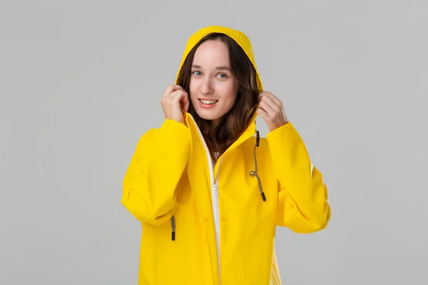 Chica morena sonriente con un impermeable amarillo. Prepárate para el mal tiempo . —  Fotos de Stock