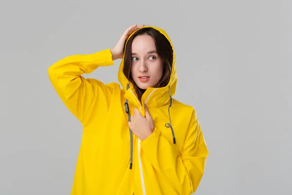 Smiling brunette girl in a yellow raincoat. Get ready for bad weather.