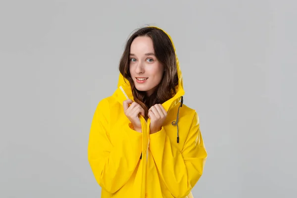 Chica morena sonriente con un impermeable amarillo. Prepárate para el mal tiempo . —  Fotos de Stock