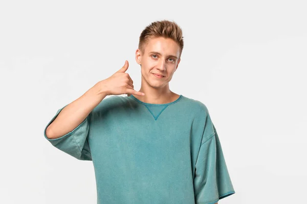 Pohledný teenager v zeleném tričku, držící se za ruce v gestu volání. Koncept komunikace. — Stock fotografie