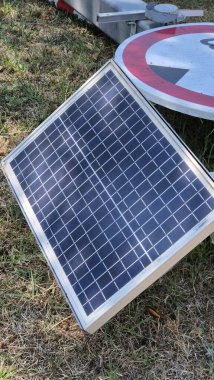 Güneş enerjisiyle çalışan yol bariyeri ve tabela yerde yatıyor, hasarlı ve servis dışı. Olay yerinde vandalizm, bozuk altyapı ve kamu güvenliği ve taşımacılık sistemleri üzerindeki etkisi vurgulanıyor.