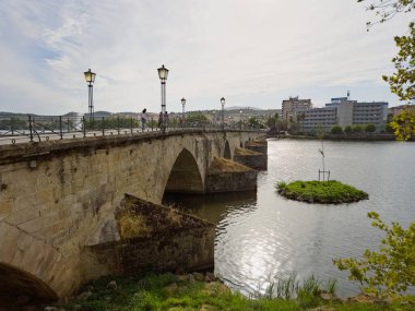 Portekiz Mirandela 'daki Tua Nehri üzerindeki taş köprü granit kemerler ve yaya kullanımıyla. Ağustos 2025, eski şehir taraflarını birbirine bağlayan barışçıl tarihi dönüm noktası.