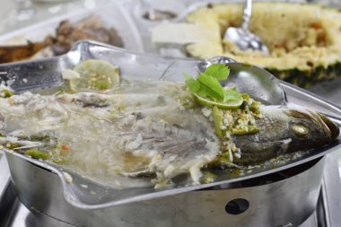 Limonlu ve bitkisel süslemeli haşlanmış balık, lezzetli deniz ürünleri çorbası ve acı biber. Parlak aroma ve iştah açıcı.