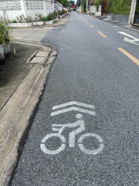 Bisiklet yolu, şehir caddesinde asfalt ikamet yeri trafik sembolü bisikletçi kaldırım şeridi, kaldırım kenarı, kaldırım kenarı, kaldırım evi çitleri yeşil, beton, sokak tabelası, sessiz yol işareti.