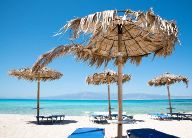 İki şezlonglar altında şemsiye içinde tropikal plaj sakin denizde