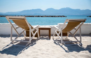 İki şezlonglar içinde tropikal plaj sakin denizde