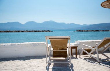 İki şezlonglar altında şemsiye içinde tropikal plaj sakin denizde