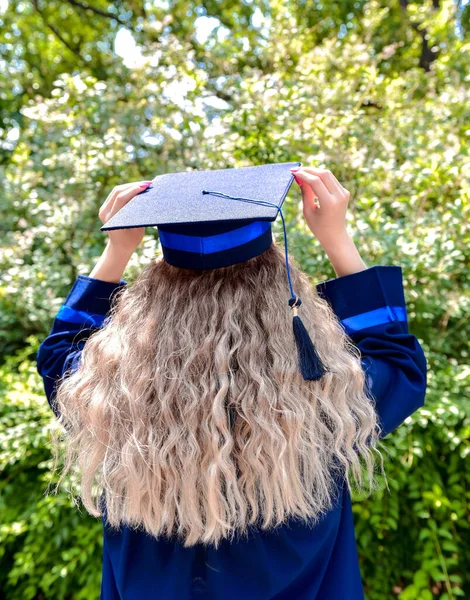 Young female student dressed in  graduation gown.