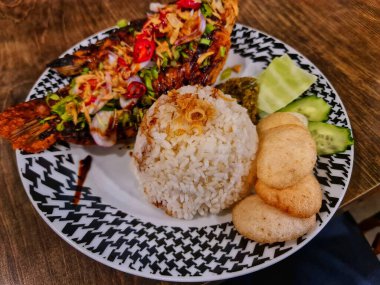 Lezzetli bir yemek için pirinçli, taze salatalıklı ve krakerli kızarmış balık. Yemek blogları ve Asya tarifleri için afiyet olsun..