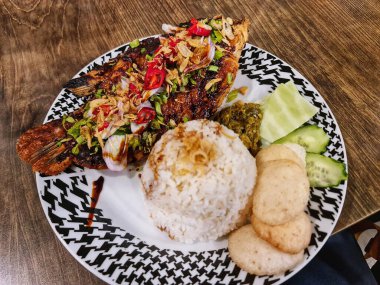 İçinde pilav, taze salatalık ve yemek blogları ve mutfak promosyonları için mükemmel baharatlar olan ızgara balık tabağı..