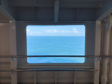 Scenic view from a ferry window reveals expansive ocean waters and bright blue skies, creating a peaceful atmosphere for maritime journeys