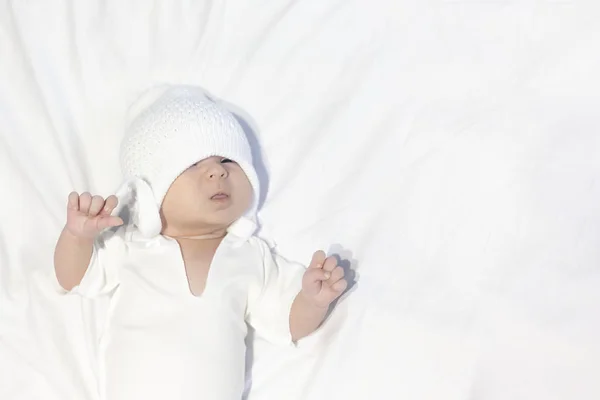 Nieuwsgierig Baby Jongetje Dragen Witte Gebreide Muts Liggend Witte Achtergrond — Stockfoto