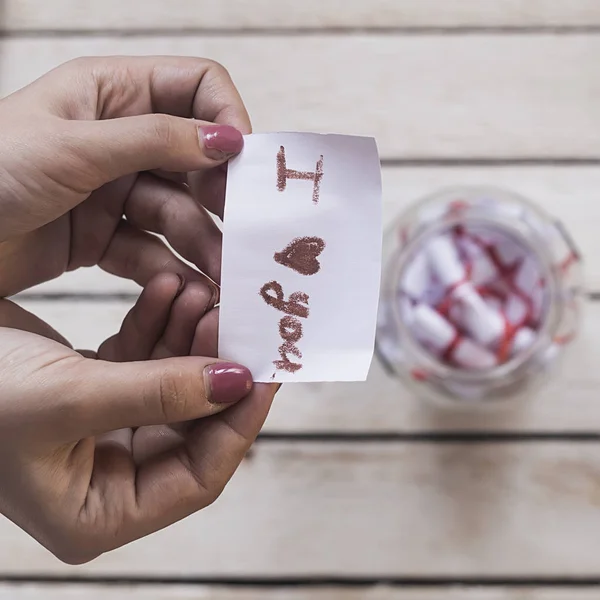 I Love you text on rolled paper. Female opening a gift glass jar with wishes and desires. A gift from her lover