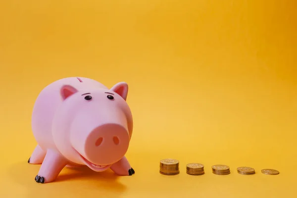 Sparschwein und abnehmende Stapel von Münzen. Finanzkonzepte — Stockfoto