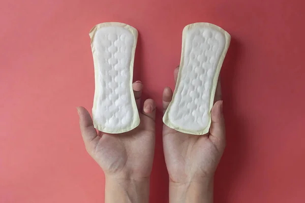 Woman's hands holding two feminine hygiene pads. Hands of female hold menstrual pads or sanitary napkins for women — Stock Photo, Image