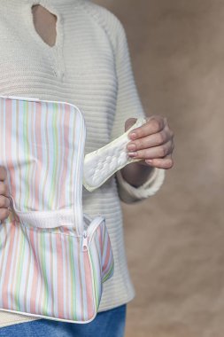 Genç kadının çanta hijyen ped koyarak dikey fotoğraf