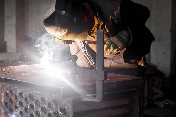 L'homme soude le métal. Acier de soudage des travailleurs dans l'industrie avec des gants de sécurité masque de sécurité et de l'équipement de sécurité. Industrie métallurgique concept de soudage — Photo