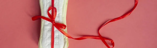 Ein Stapel Damenbinden oder Damenbinden, die mit einem roten Band auf rosa Hintergrund gebunden sind. Kritische Tage, intime, historische Tage — Stockfoto